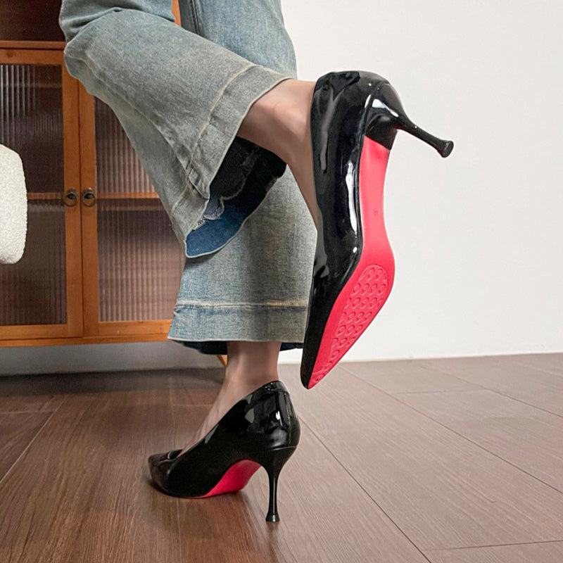 Sapatos de salto agulha de senhora em verniz com sola vermelha.