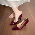 Sapatos de salto agulha de senhora em verniz com sola vermelha.